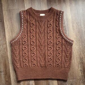 Cable knit sweater vest with whipstitch detail